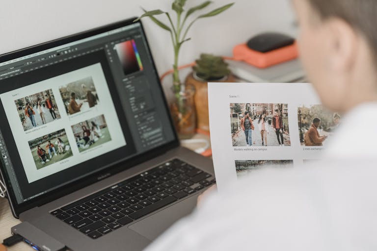 A man analyzes photo edits on a laptop, focusing on design details in a cozy home office environment.