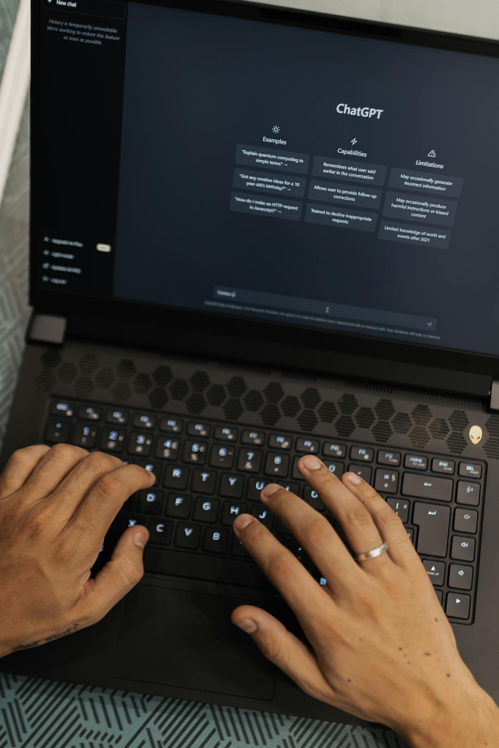 Hands typing on a laptop displaying the ChatGPT interface, showcasing AI technology.